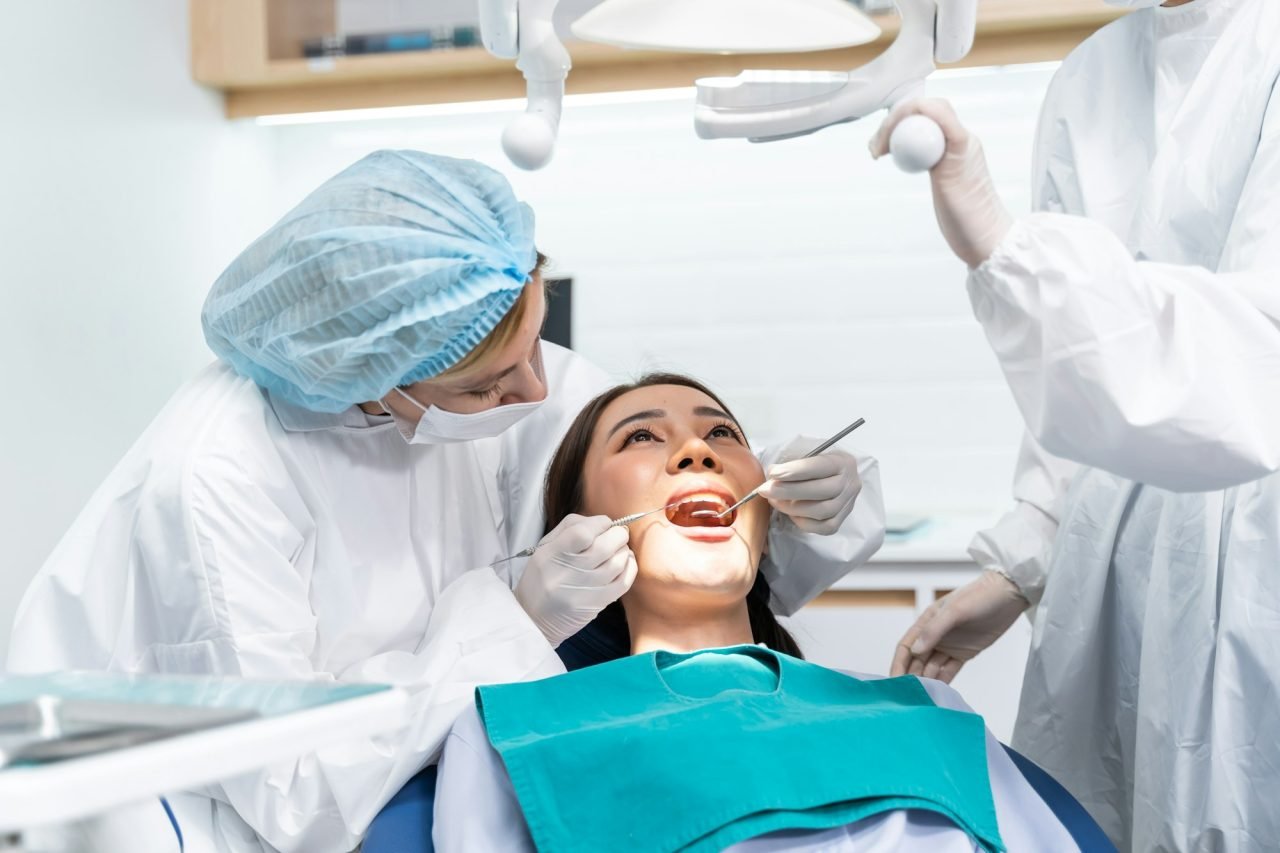 caucasian dentist examine tooth for young girl at dental health clinic