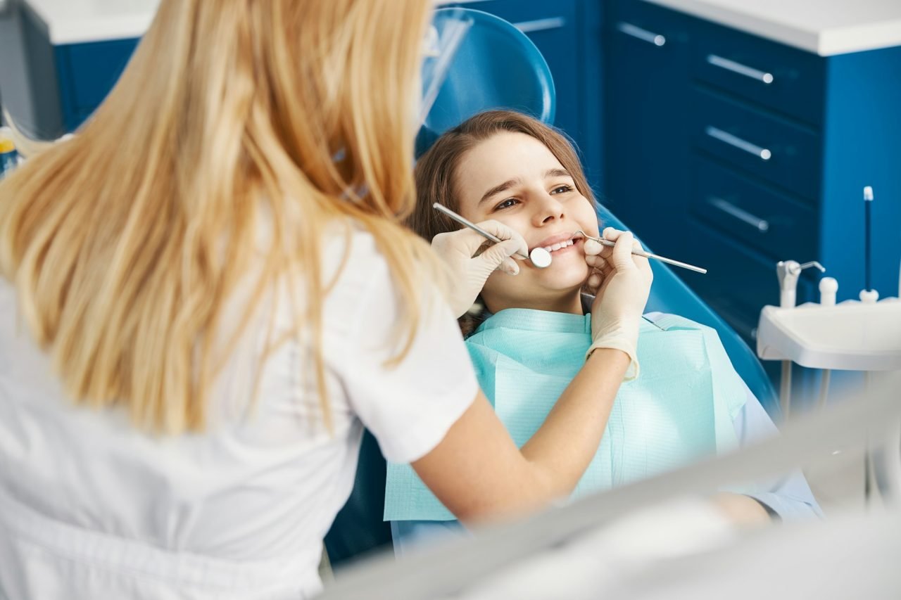 dental professional conducting dental inspection with probe and mirror
